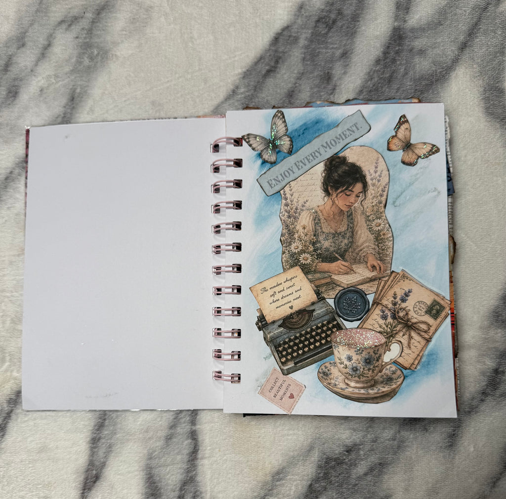 Blue collage page: “Mini junk journal collage page with butterflies, a vintage typewriter, teacup, and ‘Enjoy every moment’ lettering.”